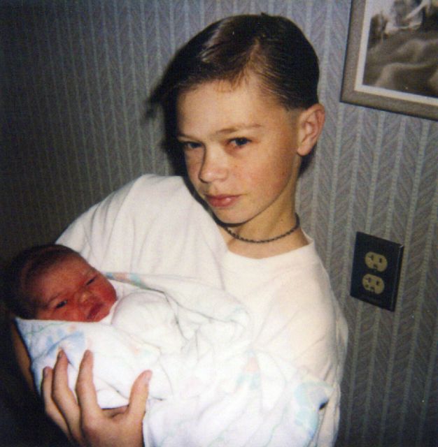 Tim holding the newborn Christina in the hospital.